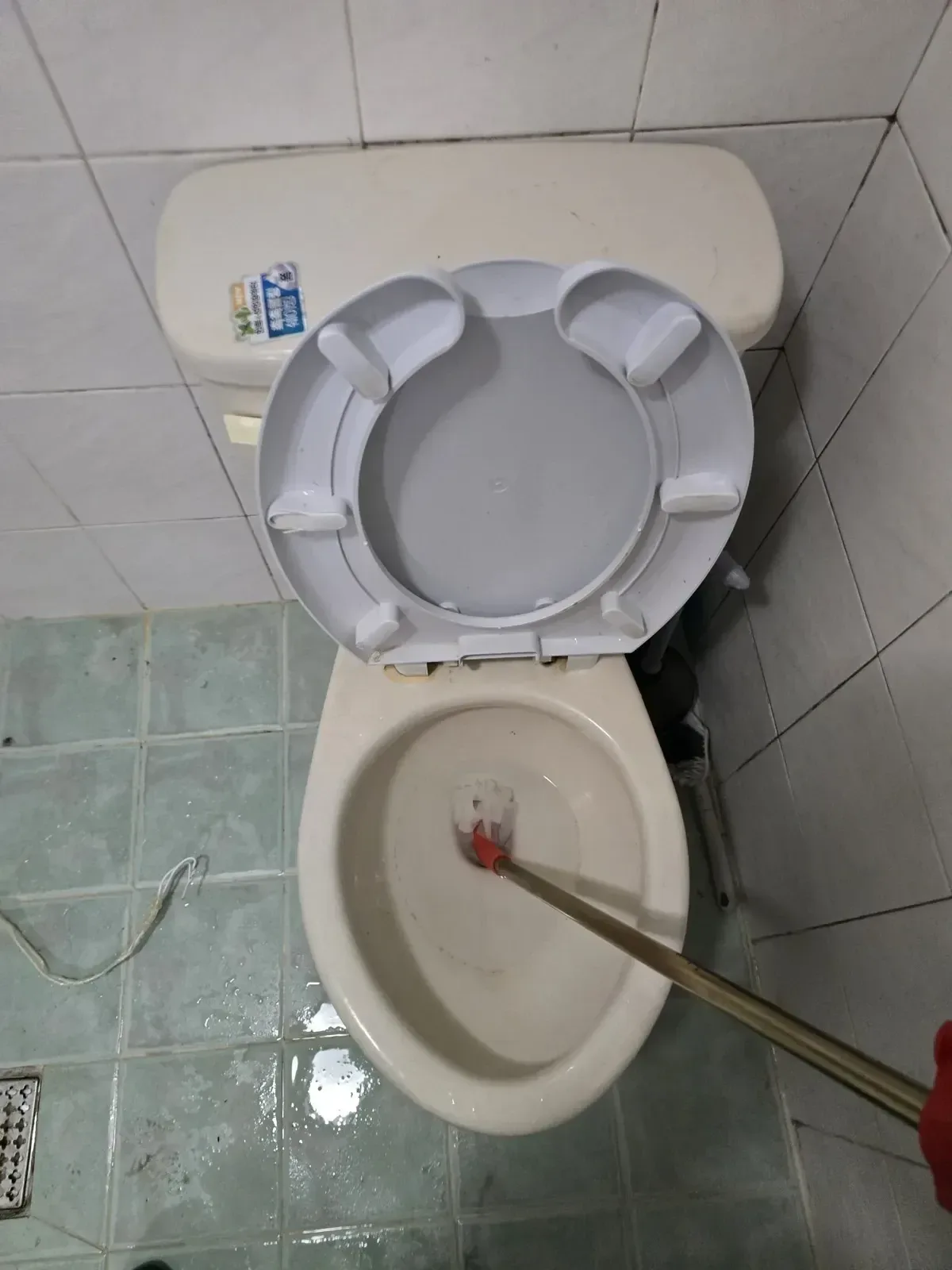 계양구변기막힘, 물이 고인 양변기 안쪽을 집게로 확인하는 모습