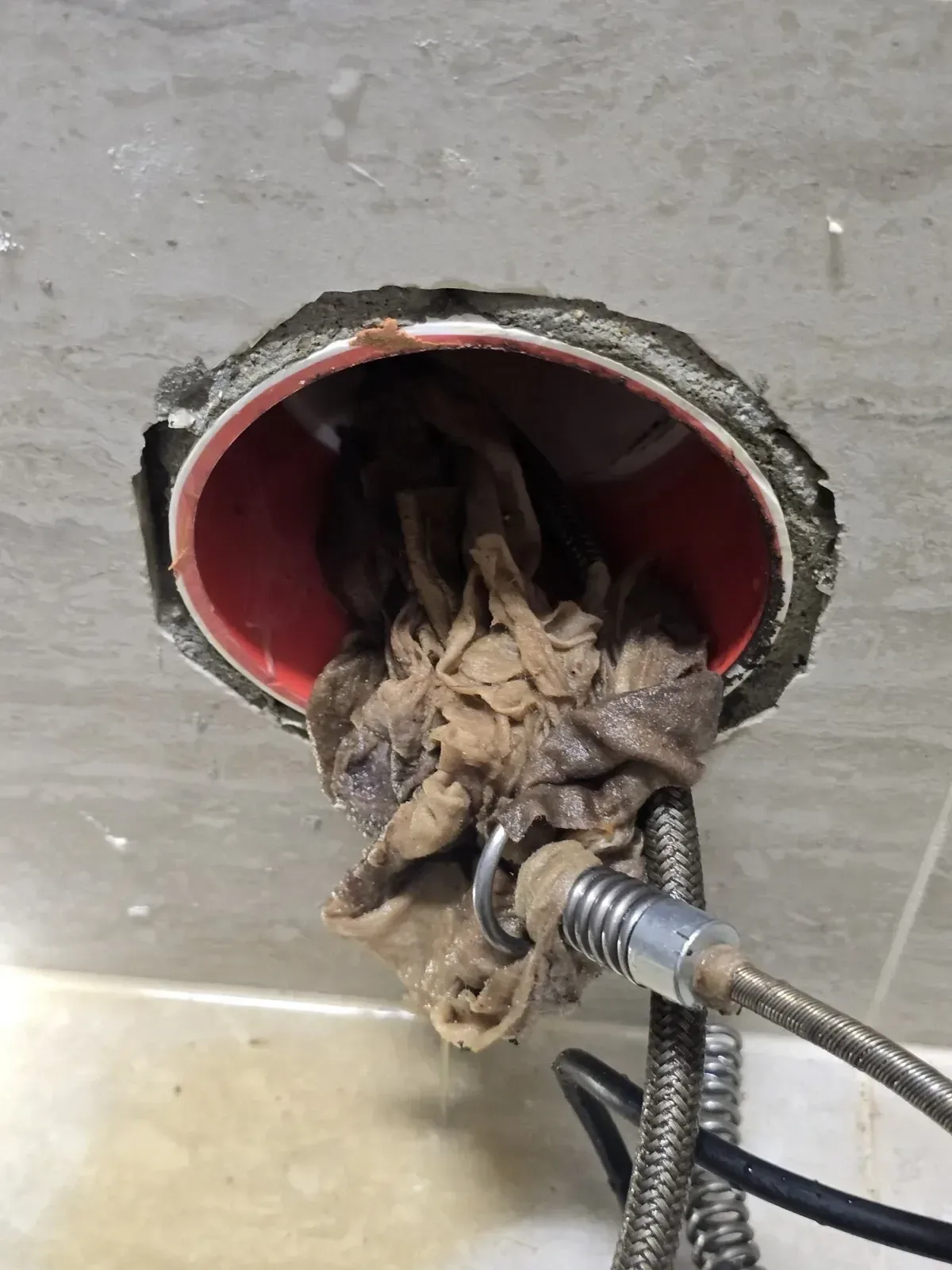변기 뒤 벽 배수관에서 끌어낸 휴지와 물티슈 뭉치